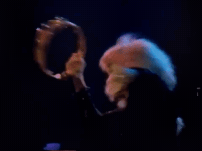 Woman Singing Into Microphone On Stage With Blue Light GIF