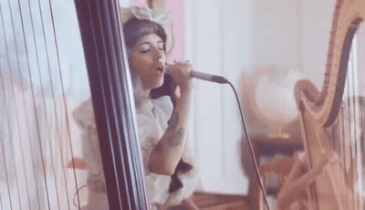 Woman Singing Into Microphone Playing Harp GIF