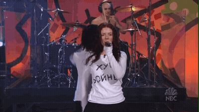 Woman Singing Into Microphone Wearing XXL Shirt GIF
