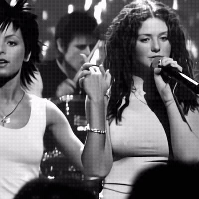 Woman Singing Into Microphone With Another Woman Behind GIF
