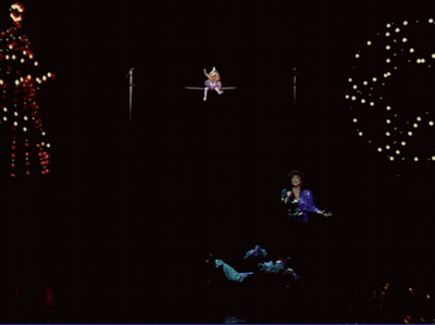 Woman Singing Into Microphone With Christmas Tree GIF
