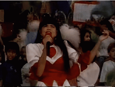 Woman Singing Into Microphone With Crowd And TCS Shirt GIF
