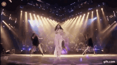 Woman Singing Into Microphone With Dancers GIF
