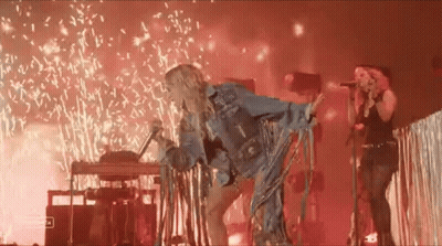 Woman Singing Into Microphone With Fireworks GIF