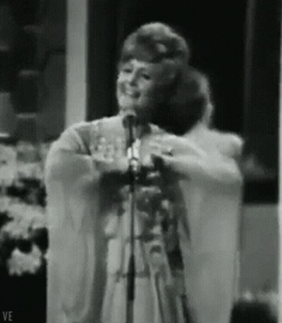 Woman Singing Into Microphone With Letters VE GIF