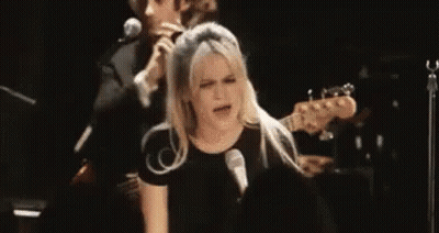 Woman Singing Into Microphone With Man Playing Guitar GIF