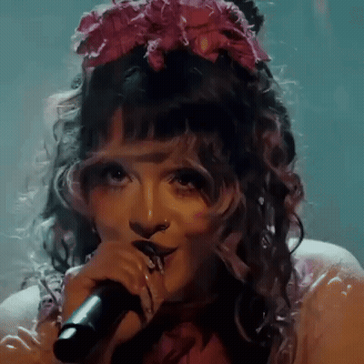 Woman Singing Into Microphone With Pink Flower GIF