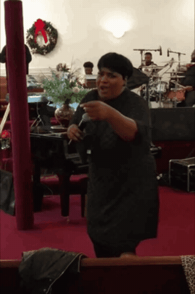 Woman Singing Into Microphone With Wreath GIF