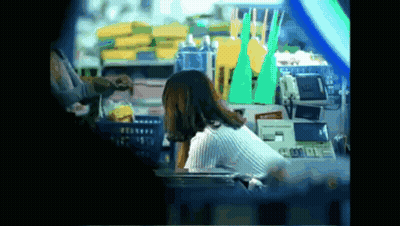 Woman Sits at Counter in Front of Machine Saying A