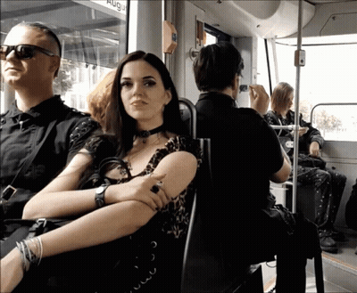 Woman Sits On Bus With Sign Saying Aug GIF