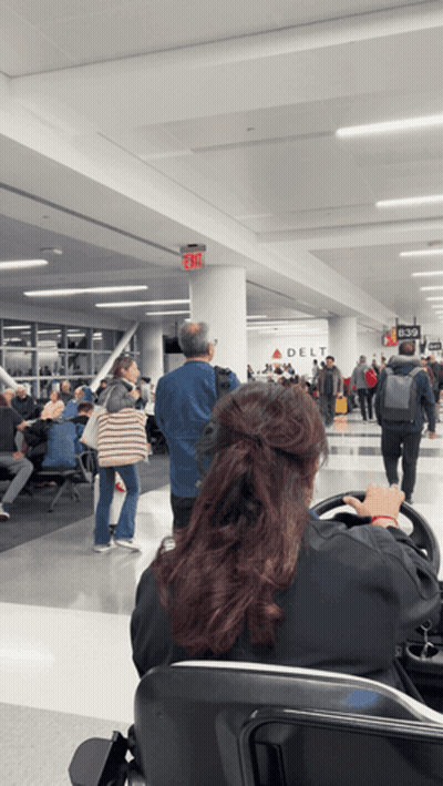 Woman Sitting at Airport With Delta Sign