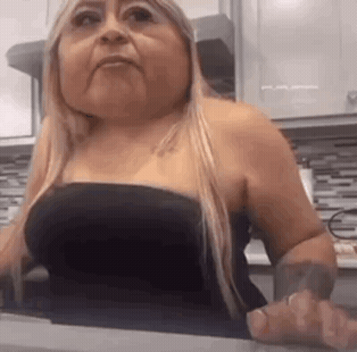 Woman Sitting At Kitchen Counter In Black Top GIF
