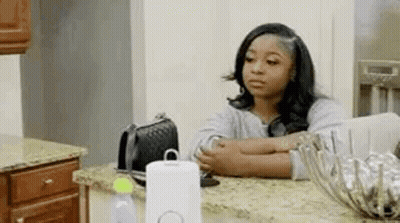 Woman Sitting At Kitchen Counter Looking At Phone GIF