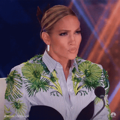 Woman Sitting At Microphone In Striped Shirt With Green Flowers GIF