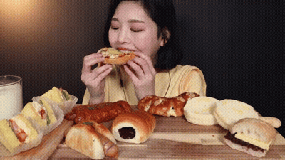 Woman Sitting At Table Eating Bread GIF