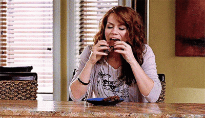 Woman Sitting At Table Eating Brownie GIF