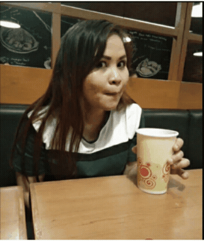 Woman Sitting At Table Holding Cup GIF