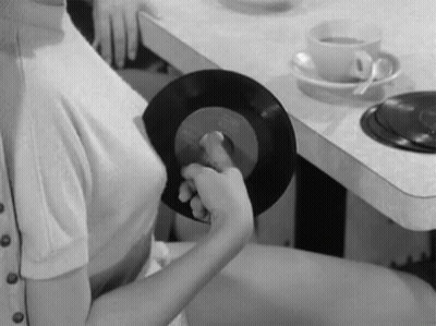 Woman Sitting at Table Holding Record