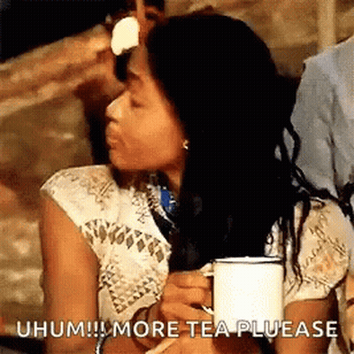 Woman Sitting At Table Holding Tea Making Funny Face GIF