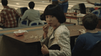Woman Sitting At Table In Bowling Alley GIF