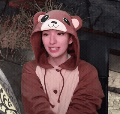 Woman Sitting At Table In Front Of TV Looking At Camera GIF
