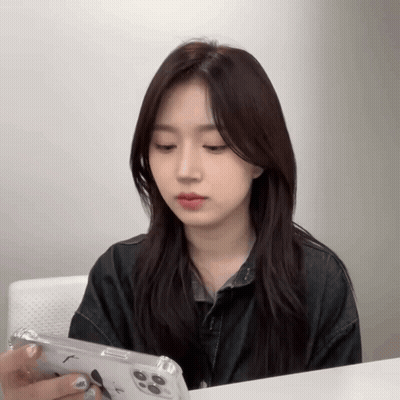 Woman Sitting At Table Looking At Cell Phone GIF