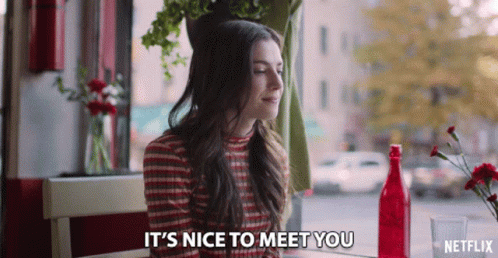 Woman Sitting At Table Saying It's Nice To Meet You In Netflix Ad GIF