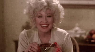 Woman Sitting At Table Smiling Holding Meat GIF