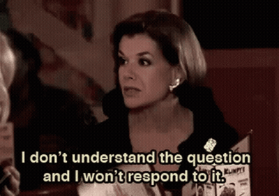 Woman Sitting At Table Talking To Another Woman Holding Menu GIF
