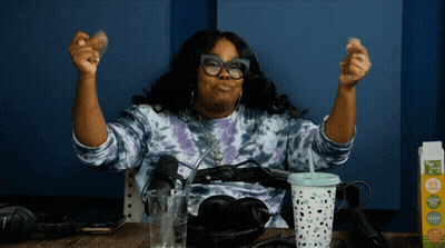 Woman Sitting At Table With Arms Up Next To Tropicana Carton GIF