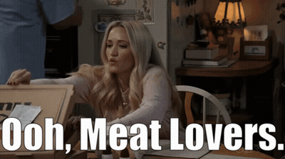 Woman Sitting At Table With Box Saying Ooh Meat Lovers GIF