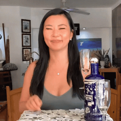 Woman Sitting At Table With Cabouin Bottle GIF