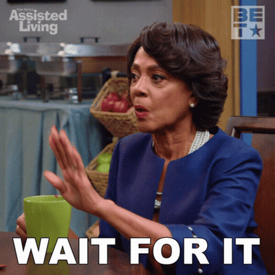 Woman Sitting At Table With Coffee And Assisted Living Sign GIF