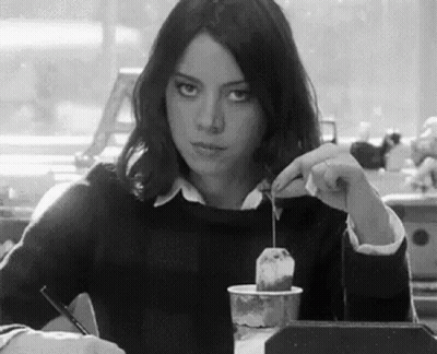 Woman Sitting At Table With Coffee And Tea Bag GIF