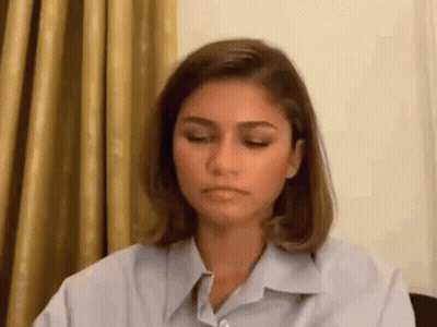 Woman Sitting At Table With Eyes Closed GIF
