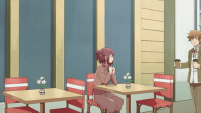 Woman Sitting At Table With Flowers In Vase GIF