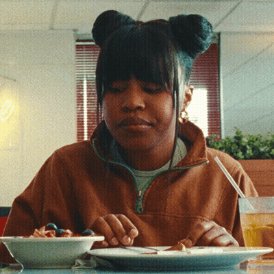 Woman Sitting At Table With Food And Fruit Bowl GIF