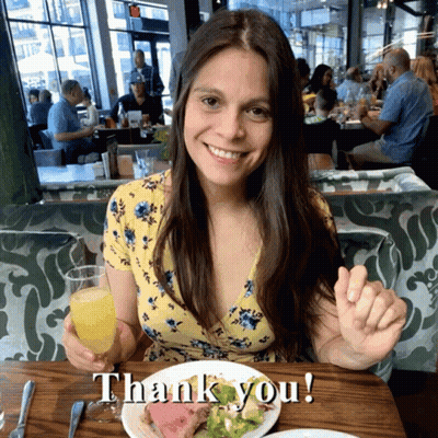 Woman Sitting At Table With Food And Orange Juice Saying Thank You GIF