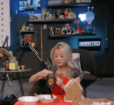 Woman Sitting At Table With Gingerbread House GIF