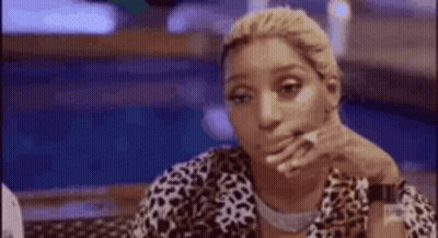 Woman Sitting At Table With Hand On Chin GIF