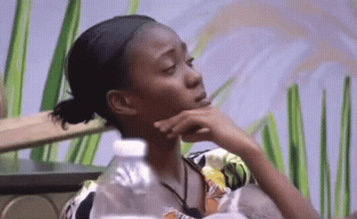 Woman Sitting At Table With Hand On Chin And Water Bottle GIF