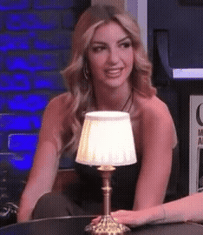 Woman Sitting At Table With Lamp GIF