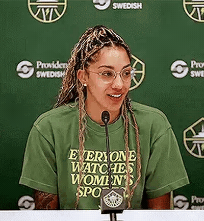 Woman Sitting At Table With Microphone GIF