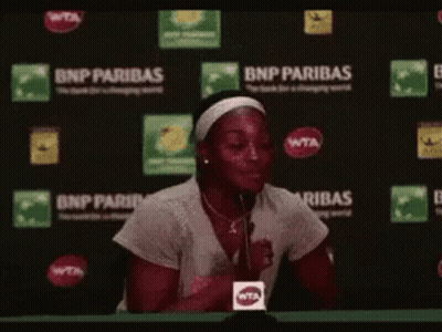Woman Sitting At Table With Microphone GIF