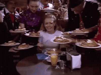 Woman Sitting At Table With Pancakes And Orange Juice GIF