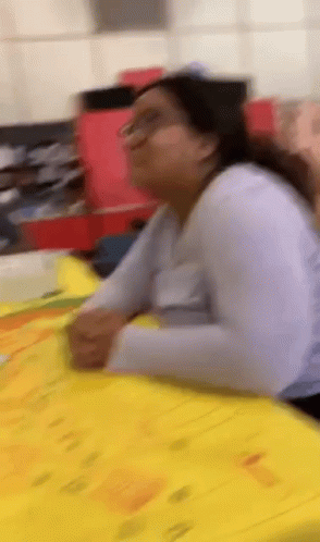 Woman Sitting At Table With Papers GIF