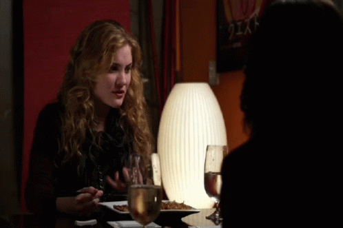 Woman Sitting At Table With Plate Of Food And Glass Of Water GIF