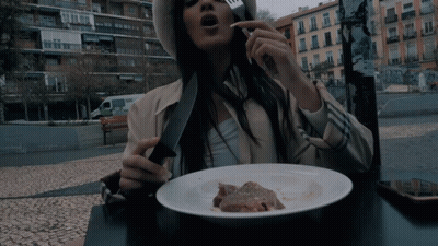 Woman Sitting At Table With Plate Of Food And Knife GIF