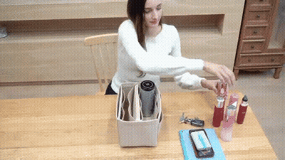 Woman Sitting At Table With Purse And Phone GIF