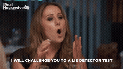 Woman Sitting At Table With Real Housewives Sign GIF